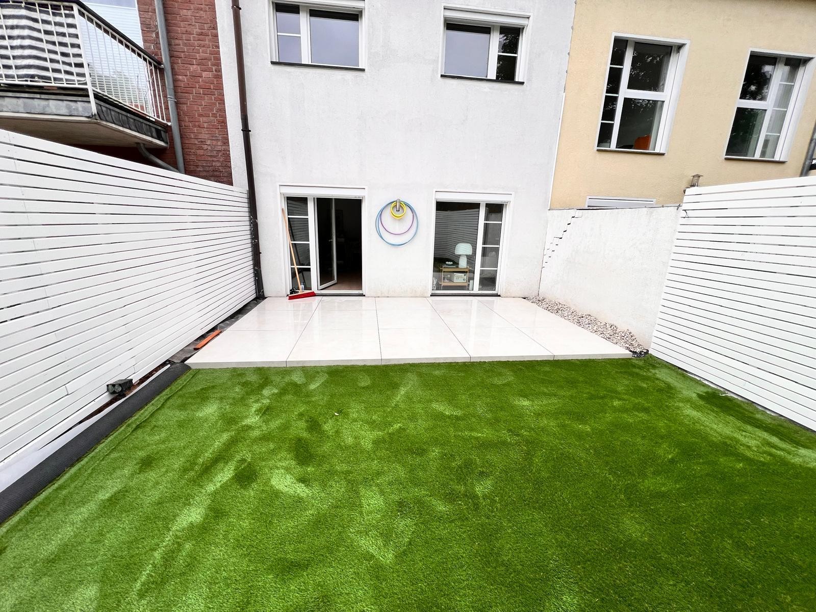 Nachher: Neuer Rollrasen und geflieste Terrasse Nachher Rollrasen verlegen Terrassenbau Fliesen Solingen fertig