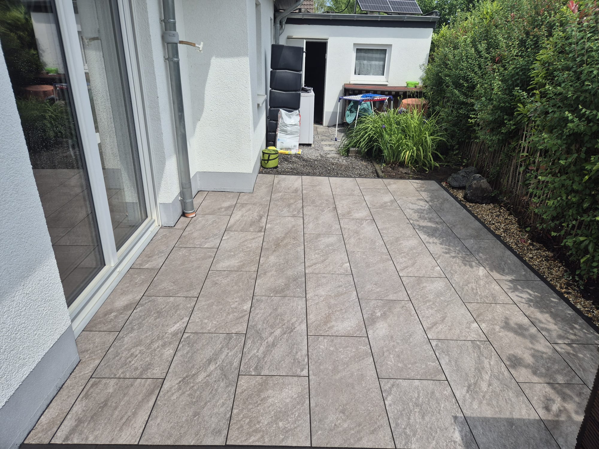 Nachher – Fertige Terrasse mit neuen Platten in Wuppertal Vohwinkel Nachher: Fertige moderne Terrasse mit neuen Pflasterplatten nach Pflasterarbeiten und Terrassenbau in Wuppertal Vohwinkel durch Syla Gartenb