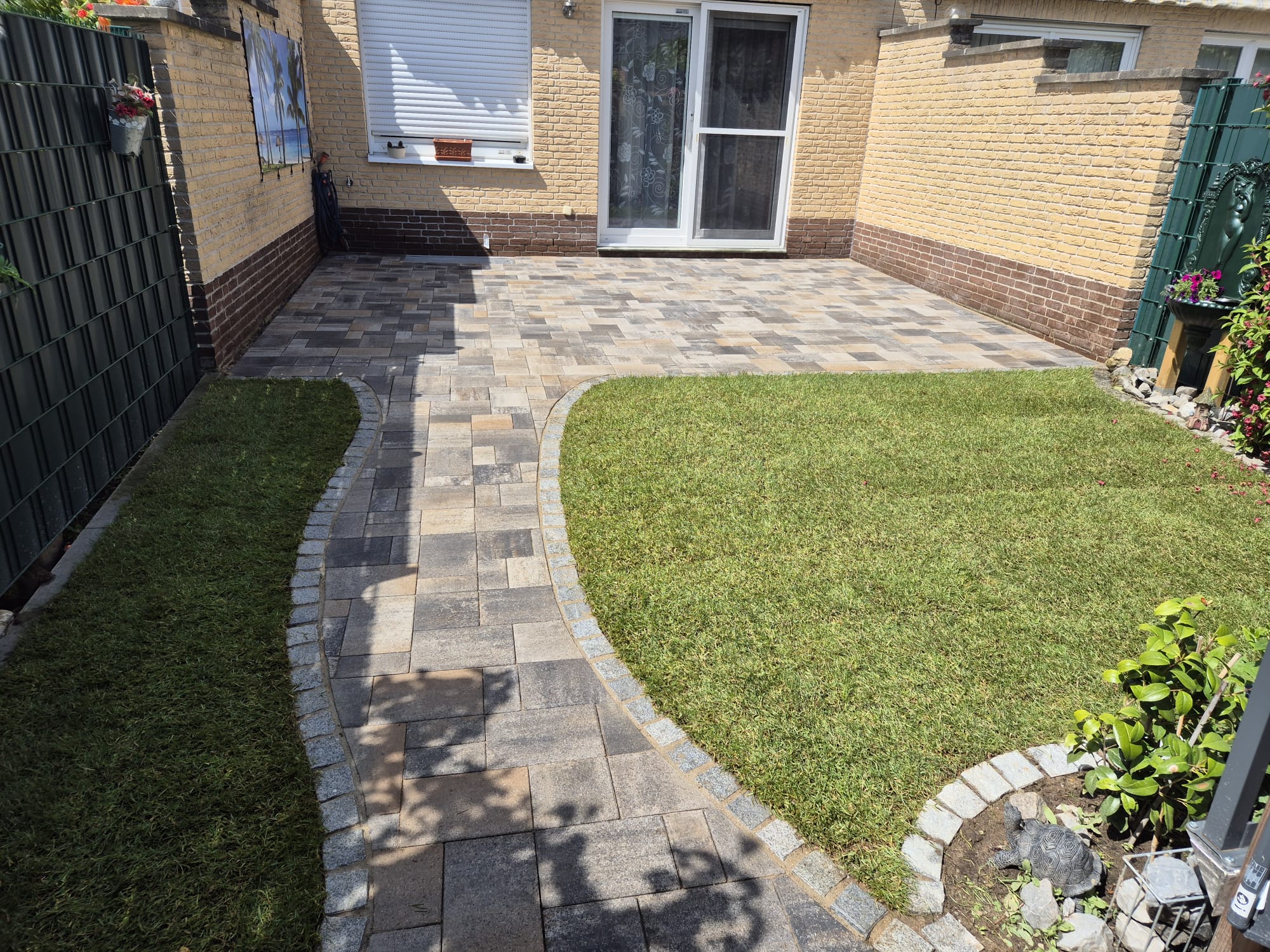 Nachher – Neue Terrasse mit farbigen Pflastersteinen und Gartenweg in Wuppertal Cronenberg Nachher: Moderne Terrasse mit farbigen Pflastersteinen und geschwungenem Gartenweg nach Pflasterarbeiten in Wuppertal Cronenberg durch Syla