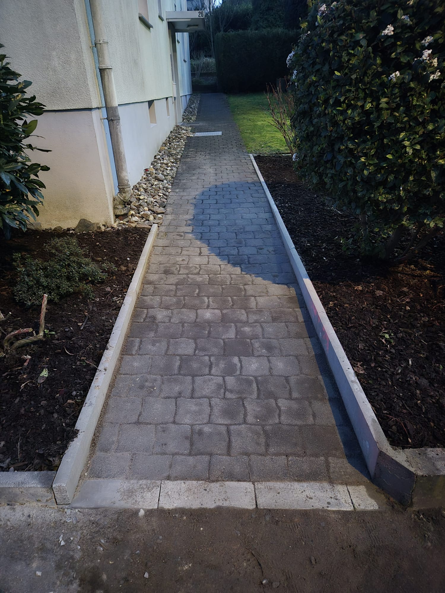 Nachher – Neuer präzise verlegter Gartenweg nach Pflasterarbeiten in Hilden Nachher: Moderner, sauber und präzise verlegter Gartenweg nach Pflasterarbeiten in Hilden durch Syla Gartenbau